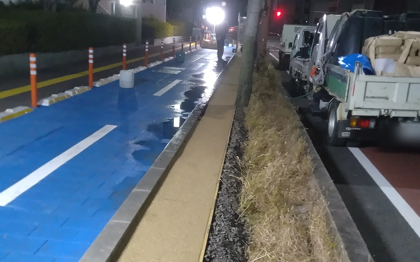 夜間の道路脇。刈った草を運び出し、縁に砂利を敷いた状態