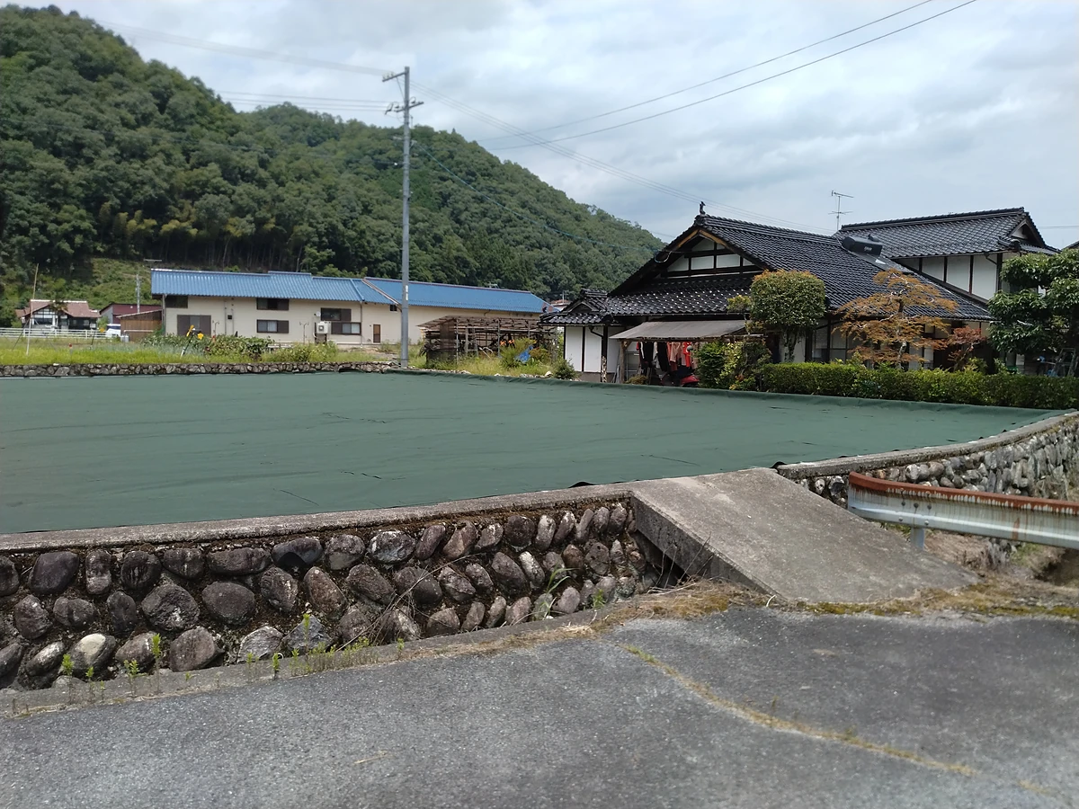 施工後：同じ土地の一面に防草シートを張り終えた状態