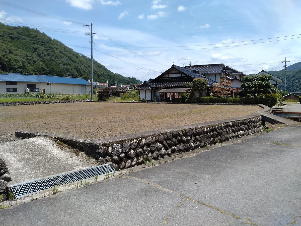 施工前：石垣の上の土地。刈ったあとの地面が見えている